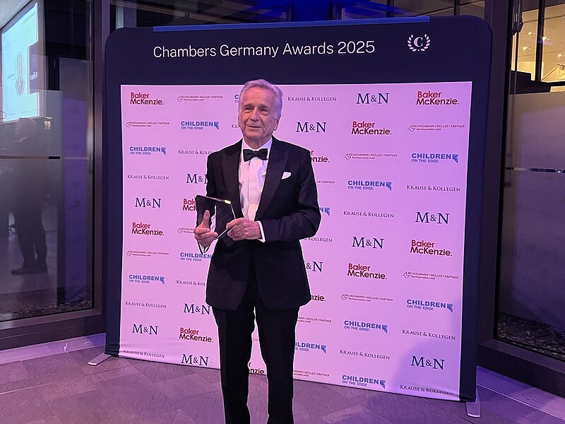 Auf dem Bild ist Dr. Reinhard Dallmayr zusehen, welcher den Lifetime Achievement Award in den Händen hält.